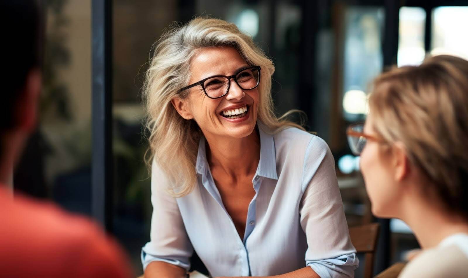 A woman with glasses smiling.