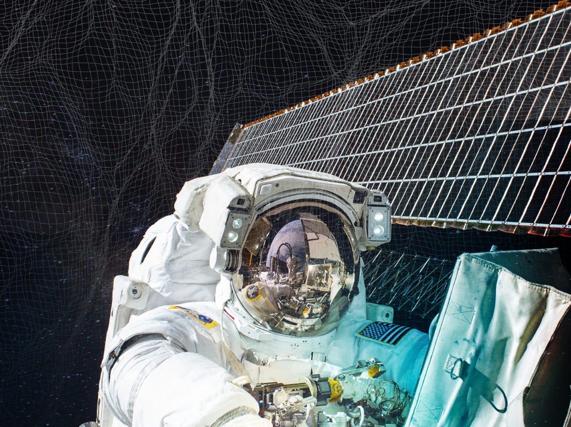 Astronaut in outer space working on a satellite, surrounded by a net.