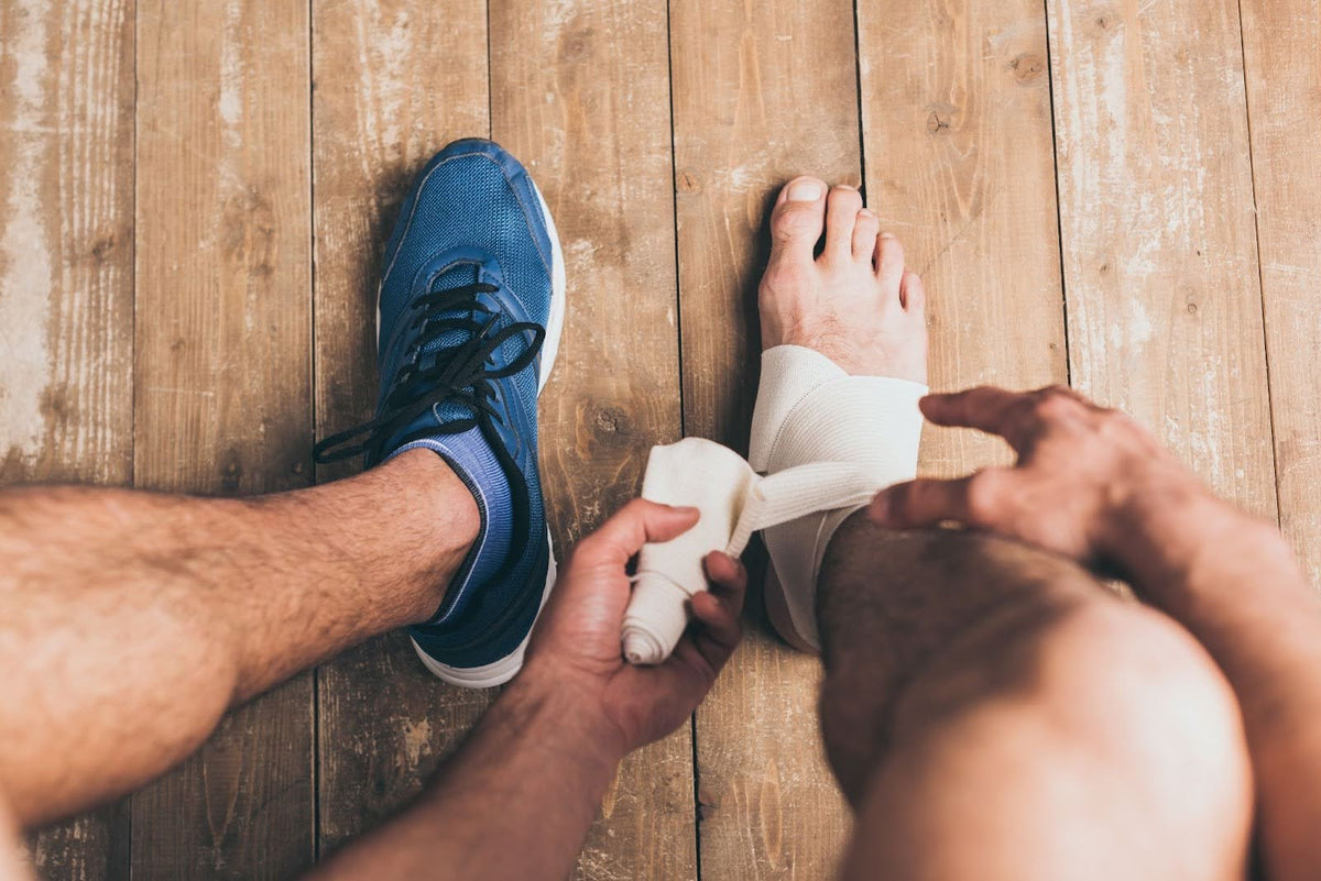 A man wrapping bandages onto his foot.